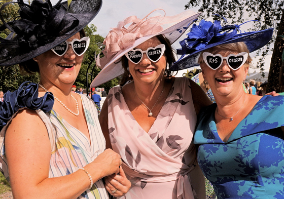 Wedding guests wearing white love heart glasses and smiling